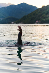 A professional triathlete trains with unwavering dedication for an upcoming competition at a lake,...