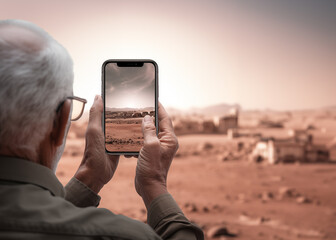 Back view Elderly man take photo with mobile phone with copy space. - obrazy, fototapety, plakaty