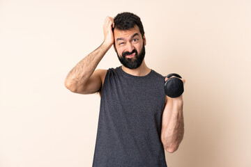 Caucasian sport man with beard making weightlifting over isolated background with an expression of...