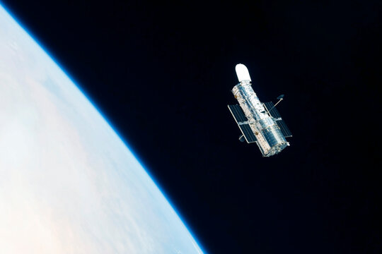 Space telescope over the planet. Elements of this image furnished by NASA