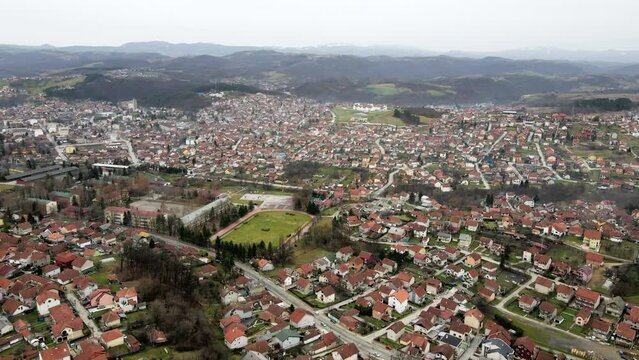 Aerial footage of town Valjevo with silhouettes of mountains in background