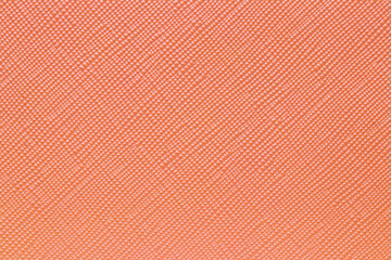 Seamless plastic texture background. Close-up of a detail from a orange surface of a cosmetic bag. Beautiful backdrop. Macro.