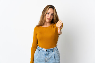 Young blonde woman isolated on blue background showing thumb down with negative expression