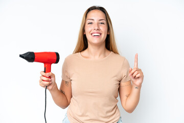 Young caucasian woman holding a hairdryer isolated on white background pointing up a great idea