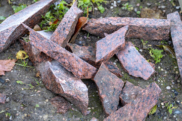red granite chips on the ground. Stone masonry, granite workshop