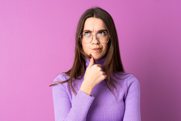 Young woman over isolated purple background having doubts and thinking