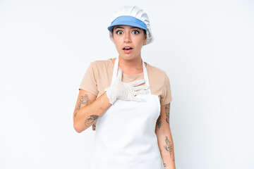 Fishmonger wearing an apron and holding a raw fish isolated on white background surprised and shocked while looking right