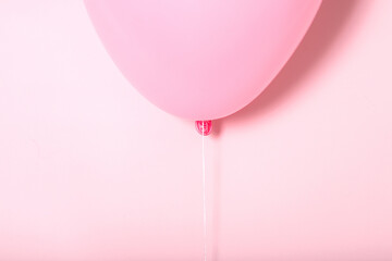 pastel pink balloon with white ribbon on pink, concept, close-up