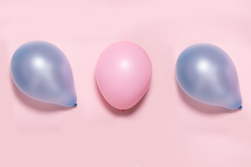 pink and blue balloons on a pink background, gender choice concept or gender party