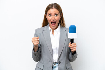 Young caucasian tv presenter woman isolated on white background celebrating a victory in winner position