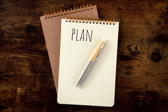 Plan. Notebook with a pen, overhead flat lay shot on a rustic wooden desk