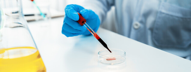 Scientific laboratory researcher drop blood sample on microscopic slide for medical examination or...