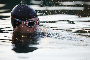 A triathlete finds serene rejuvenation in a lake, basking in the tranquility of the water after an...