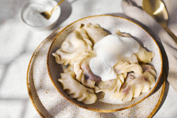 Dumplings with cherries with sour cream and sugar. Traditional dish of Russian, Ukrainian, Belarusian cuisine known as Vareniki