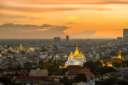 Golden Mountain Pagoda, A Buddhist Temple Or Wat Saket With The Sun In Bangkok Downtown, Urban City With Sunset Sky, Thailand. Thai Architecture Landscape Background.