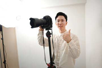 一眼レフカメラで撮影をするアジア人の男性カメラマン