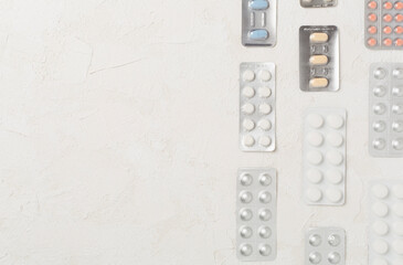 Pills in blister packaging on concrete background, top view