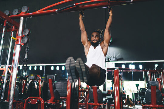 Black man doing pull ups on sports ground
