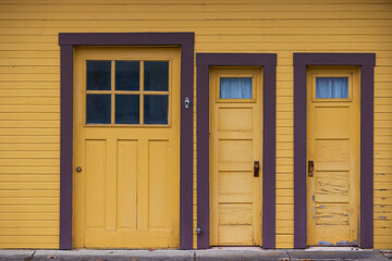 Close up of three doors on the side of a building.
