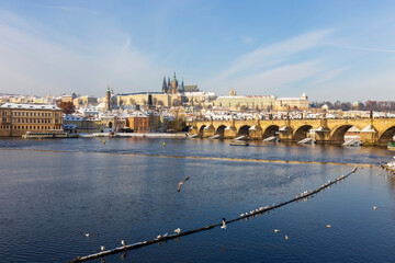 Snowy Prague Lesser Town with Prague Castle and Charles Bridge above River Vltava in the sunny Day , Czech republic