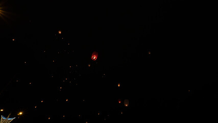 Thousands of Chinese lanterns thrown into the air light up the night sky. In Pamplona Spain.