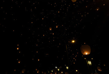 Thousands of Chinese lanterns thrown into the air light up the night sky. In Pamplona Spain.