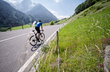 Active male tourist enjoys a scenic bicycle trip along the great alpine route.