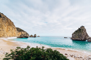 Secret beach in Sesimbra with high cliffs and sky blue water - Praia do Ribeiro do Cavalo