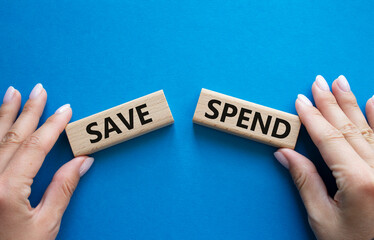 Save or Spend symbol. Concept word Save or Spend on wooden blocks. Businessman hand. Beautiful blue background. Business and Save or Spend concept. Copy space