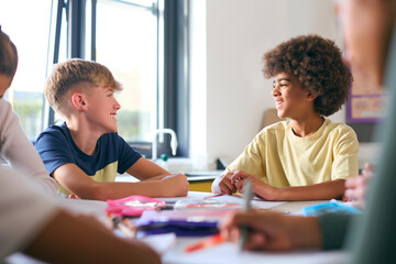 Two Male Secondary Or High School Students Sitting At Table In Science Class Working Together