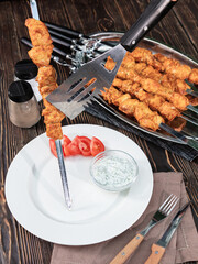 Chicken kebab on metal skewers lies on the table