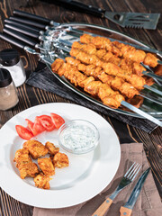 Chicken kebab on metal skewers lies on the table