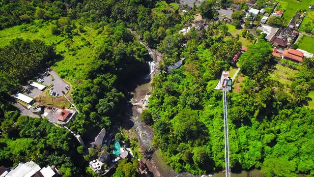 Tegenungan Waterfall surrounded by lush green tropical jungle near Ubud village at Bali Island, Indonesia. Aerial drone footage at daytime