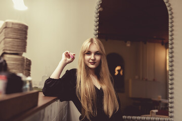 Portrait of a young beautiful blonde girl in a cafe.