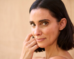 Beauty Portrait Of Smiling Mature Woman With Bare Shoulders Against Natural Background