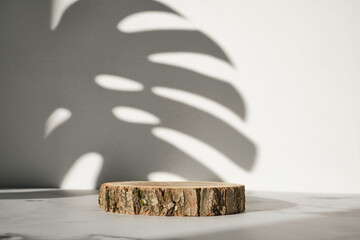 Wooden cut podium with monstera leaf shadow for natural cosmetics or products presentation