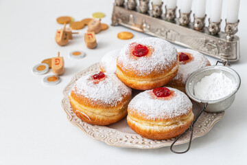 Tasty donuts with jam on wooden background - Hanukkah celebration concept	