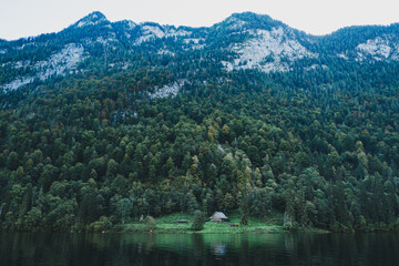 Obraz premium lake in the mountains with a small house in the middle 