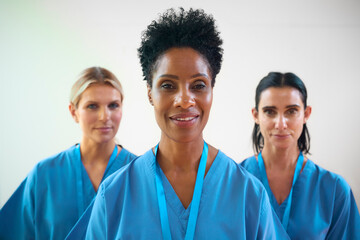 Portrait Of Mature Female Multi Cultural Medical Team Wearing Scrubs In Hospital