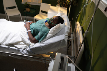 Image of a woman, African, in a hospital room, with an oxygen mask, recuperating after a severe...