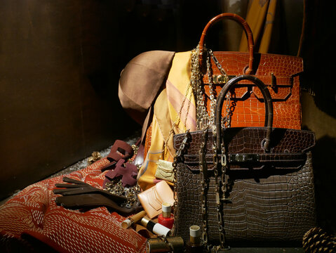 Luxury Hermes leather accessories and two iconic handbags "Birkin" in the window of the historic store in Paris
