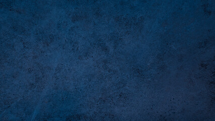 A dark blue grunge picturesque wall texture with stains and scratches on concrete surface 