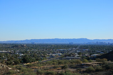 Fototapeta na wymiar Bluish haze over Arizona Capital City of Phoenix downtown under cloudless sky as seen from North Mountain Park toward South mountains