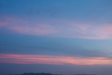 Mysterious colorful sunset sky with amazing red-orange sunlight trails surrounded by dramatic atmosphere