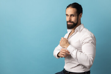 Portrait of handsome confident pensive man with beard wearing white shirt looking at camera and...