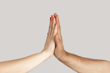 Closeup of multicultural man and woman giving each other five, racism and all lives matter. Indoor...