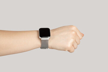 Closeup of woman hand showing smartwatch on her wrist with empty black screen. Indoor studio shot...