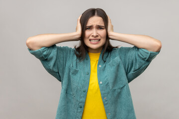 Don't want to listen anymore. Angry woman covering ears with hands to stop hear annoying talk,...