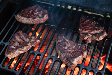 Beef rumpsteak cooked on a cast iron grate on a charcoal grill