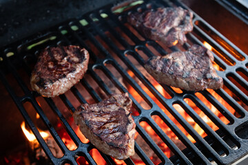 Beef rumpsteak cooked on a cast iron grate on a charcoal grill